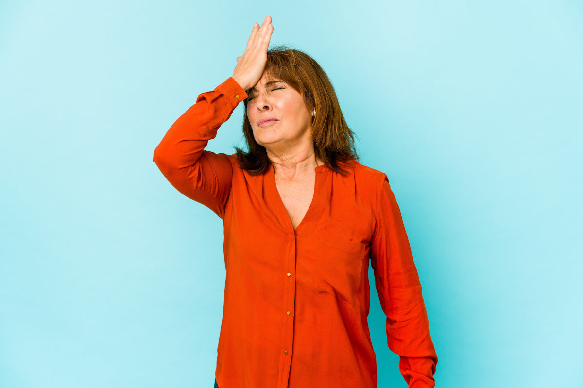 Senior woman isolated forgetting something, slapping forehead with palm and closing eyes.