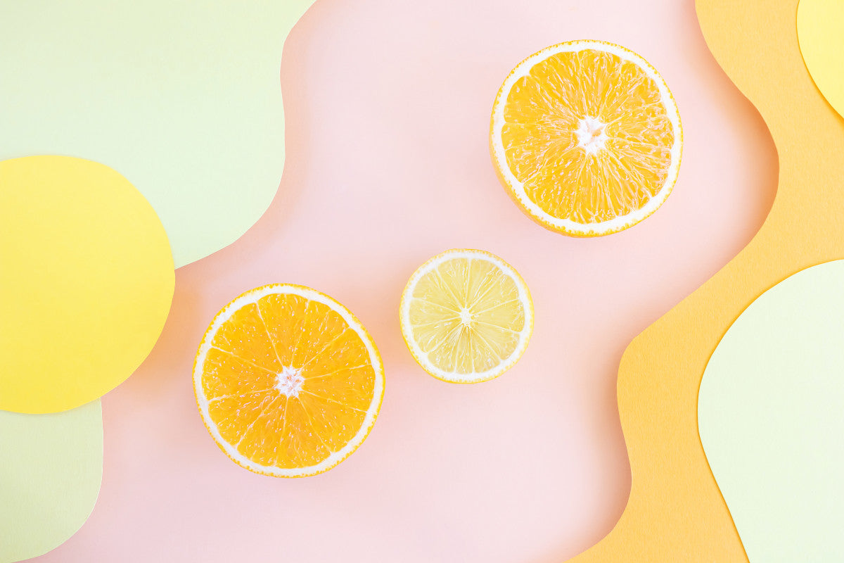 pink and yellow swirly background with three orange slices in the middle