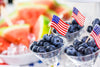 bowl of watermelon and small cups of blueberries with the American flag sticking out of them