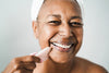 mature woman wearing a towel on her head and smiling while practicing gua sha