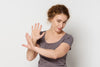 middle-aged woman holding up her arms as if to say 
