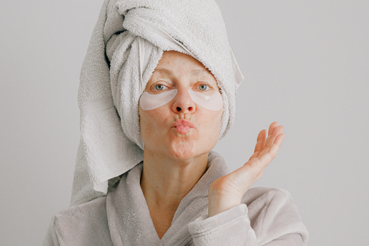 Middle-aged woman in a bathrobe and a towel wrapped around her wet hair.