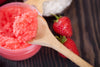 strawberry body scrub in a wooden spoon