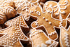 pile of various gingerbread cookie shapes, including gingerbread men, snowflakes, bells, and Christmas trees.