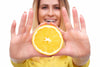 woman holding orange slice in front of her with both hands