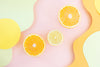 pink and yellow swirly background with three orange slices in the middle